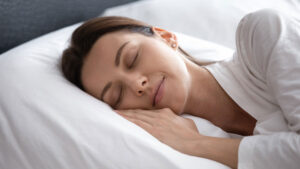 Woman sleeping on her side with her hand on the pillow